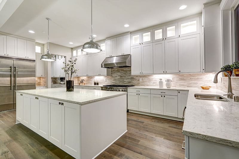 Gourmet Kitchen Features White Shaker Cabinets With Marble Countertops Stone Subway Tile Backsplash And Gorgeous Kitchen Island