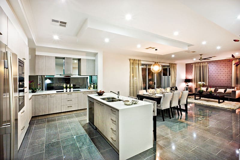 Pure White Island In A Modern And Shiny Kitchen With Dining And Living Area On The Reflective Tiles