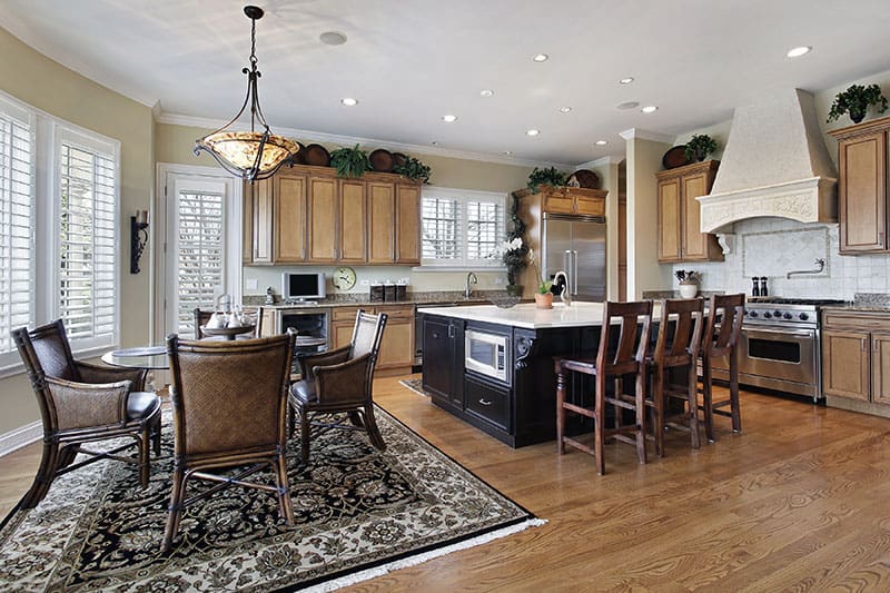 Dark Wood Island In A Spacious Kitchen With Plenty Of Chairs