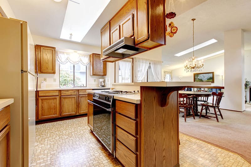 Full Of Life Kitchen Island In Bright Kitchen Room With High Vaulted Ceiling And Skylights