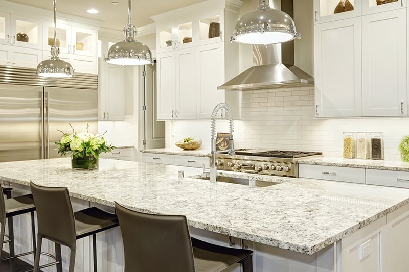 white kitchen cabinet with light granite countertops