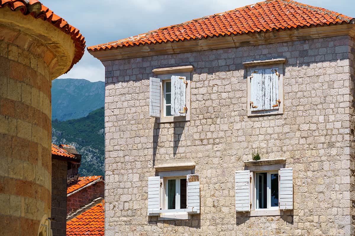 cream stone walls and white rustic shutters