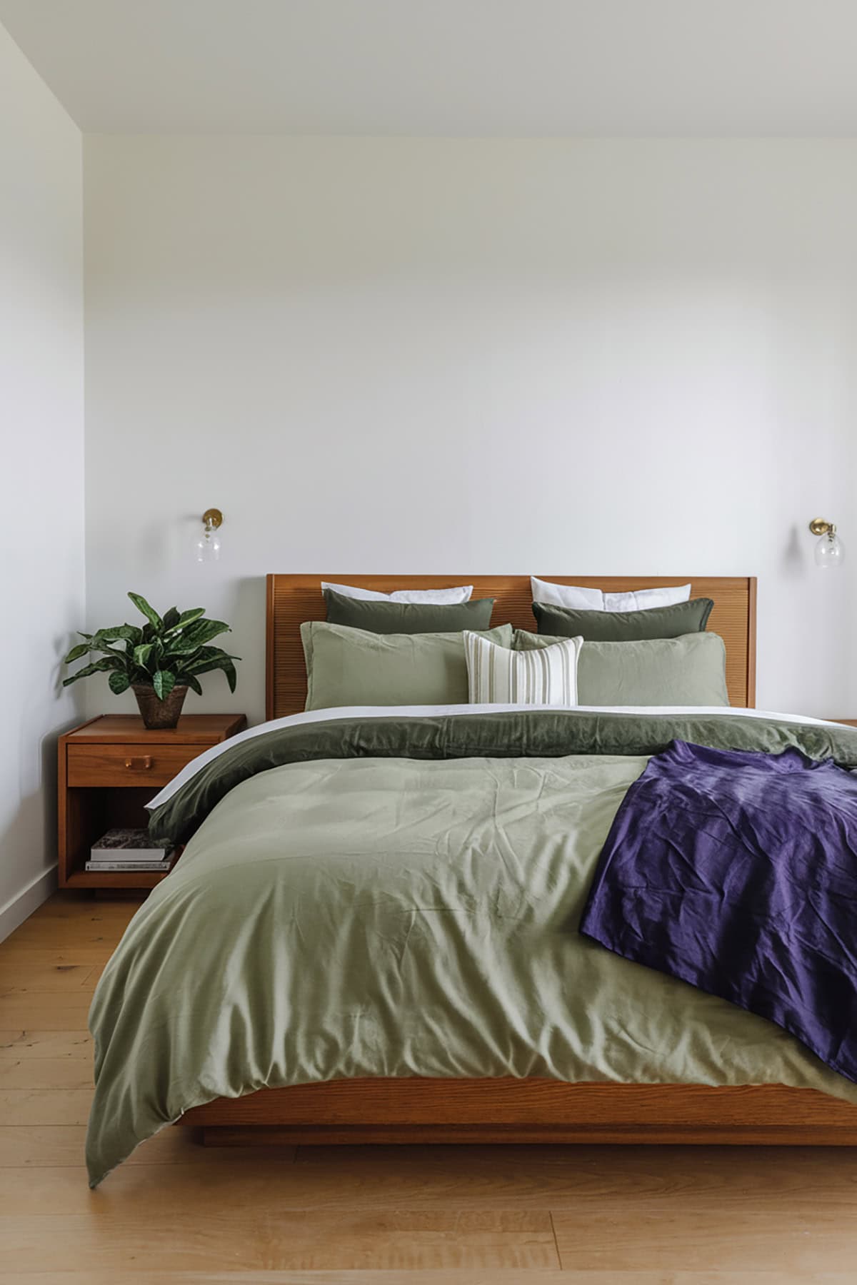 Layered Green Bedding with White Walls