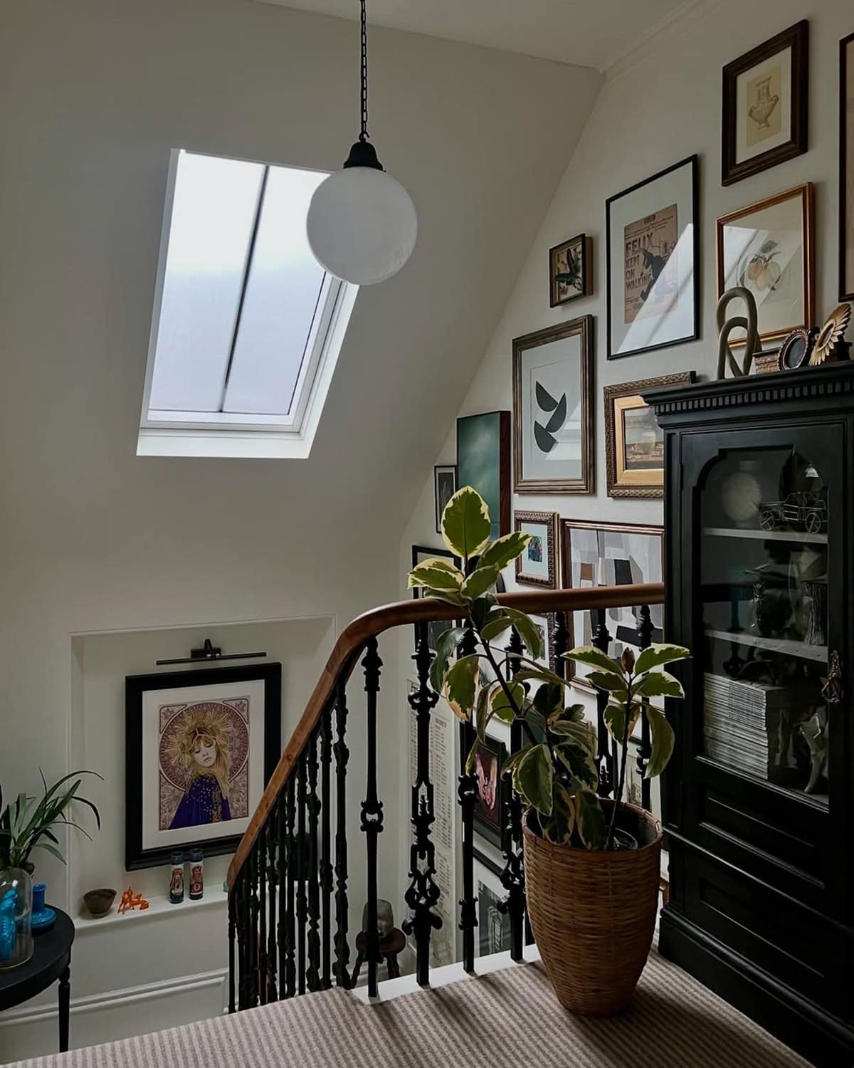 Staircase Photo Wall with Vintage Charm Under an Attic Skylight